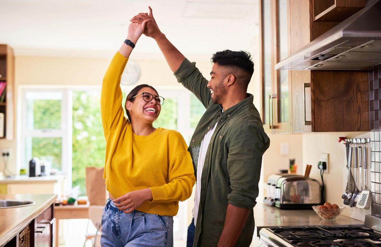 Shot-of-a-young-couple-dancing-together-in-their-kitchen