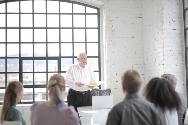 Leader communicating organisational change to a seated team